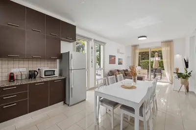 a kitchen and dining room with a white table and chairs at Villa with private pool in Pervolia, Larnaca in Pervolia