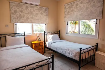 two beds in a room with two windows at Mermaid Villa 16 in Ayia Napa