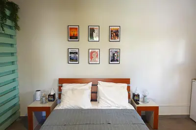 a bedroom with a bed with four pictures on the wall at Under the Palms in Nicosia