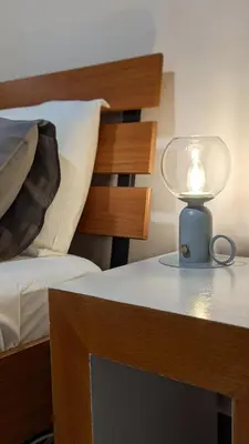a lamp sitting on a table next to a bed at Under the Palms in Nicosia