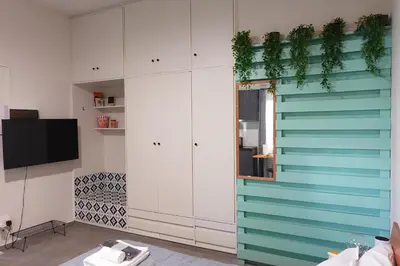 a living room with white cabinets and a tv at Under the Palms in Nicosia