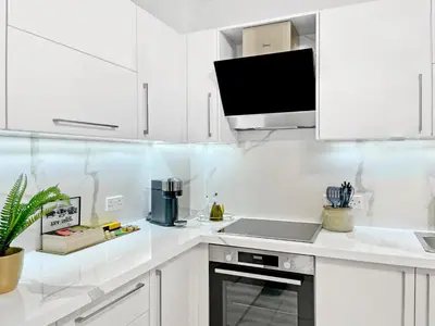 a white kitchen with a sink and a microwave at The Encino - luxury seaside suite in Larnaka