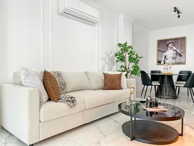 a white living room with a couch and a table at The Encino - luxury seaside suite in Larnaka