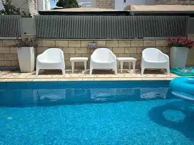 a group of chairs sitting next to a swimming pool at Villa Serenity in Protaras
