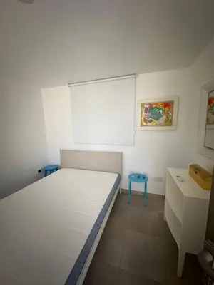 a bedroom with a white bed and a blue stool at Villa Serenity in Protaras