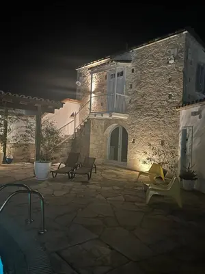a stone building with a patio at night at Little Stone House in Lymbia
