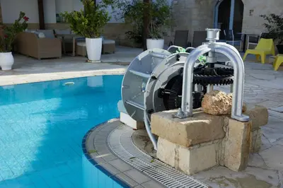 a water fountain next to a swimming pool at Little Stone House in Lymbia