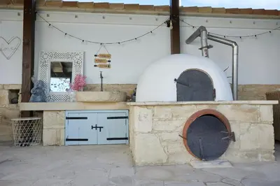 an outdoor kitchen with a pizza oven in a building at Little Stone House in Lymbia