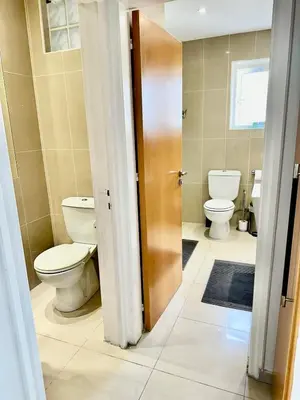 a bathroom with two toilets and a sink and a door at Superb Seaview Flat, Prime Area in Larnaka