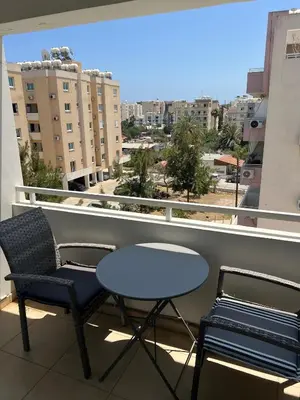 a table and chairs on a balcony with a view of a city at Superb Seaview Flat, Prime Area in Larnaka