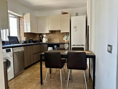 a kitchen with a table with chairs and a refrigerator at Superb Seaview Flat, Prime Area in Larnaka