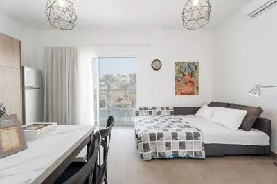 a bedroom with a bed and a kitchen with a table at SunnyVillas 1 Bedroom Central Protaras in Protaras