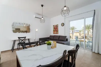 a living room with a table and chairs and a couch at SunnyVillas 1 Bedroom Central Protaras in Protaras