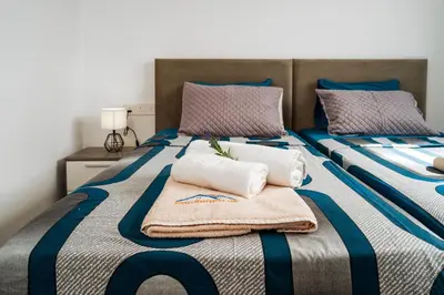 a bedroom with two beds with towels on them at SunnyVillas 1 Bedroom Central Protaras in Protaras
