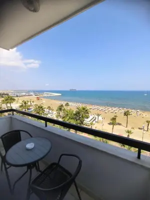 a balcony with a table and chairs and the beach at Sunorama Beach Garden - Seaview in Larnaka
