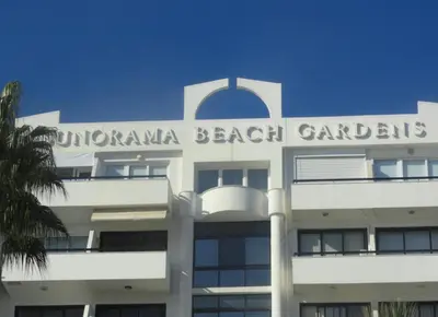 a white building with the words dominicanana beach gardens on it at Sunorama Beach Garden - Seaview in Larnaka