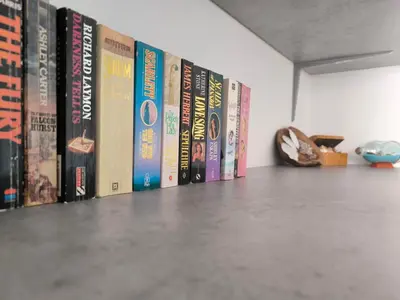a row of books lined up on a shelf at Sunorama Beach Garden - Seaview in Larnaka