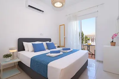 a white bedroom with a large bed and a balcony at Villa Angelina - 300m from Kapparis beach in Paralimni