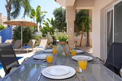 a table with plates and glasses of orange juice at Villa Angelina - 300m from Kapparis beach in Paralimni