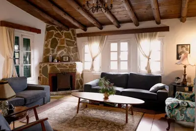 a living room with couches and a stone fireplace at Semiramis Boutique Hotel & Spa in Kato Platres