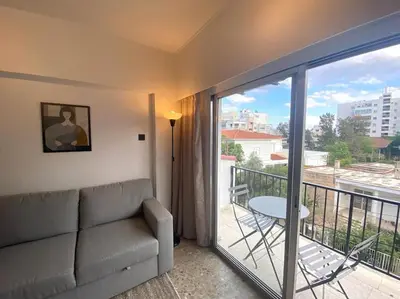a living room with a couch and a balcony at Cozy 1 BDR in Nicosia city center - Aiantos By Platform 357 in Strovolos