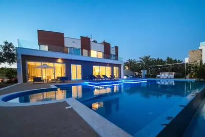 a large house with a swimming pool in front of it at Royal Oasis Villa in Ayia Napa