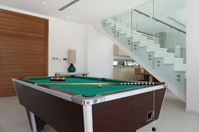 a pool table in a room with a staircase at Royal Oasis Villa in Ayia Napa