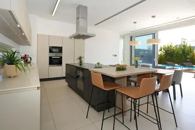 a kitchen with a large island with a table and chairs at Royal Oasis Villa in Ayia Napa