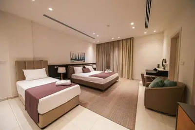 a hotel room with two beds and a couch at Royal Oasis Villa in Ayia Napa