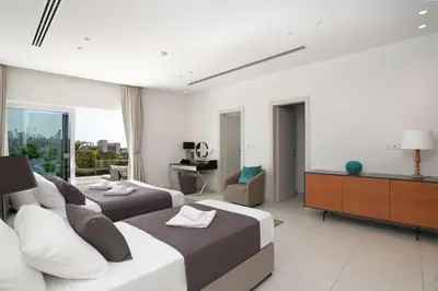 a hotel room with two beds and a television at Royal Oasis Villa in Ayia Napa