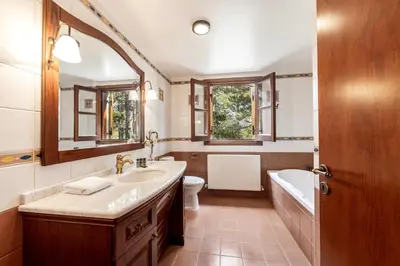 a bathroom with a sink and a tub and a toilet at Troodos Mature Pine Chalet in Pedoulas