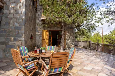 a wooden table and chairs on a patio at Troodos Mature Pine Chalet in Pedoulas