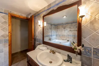 a bathroom with a sink and a mirror and a tub at Troodos Mature Pine Chalet in Pedoulas