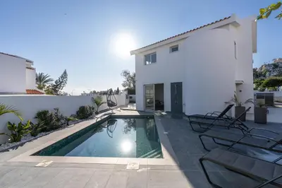 a villa with a swimming pool next to a house at Mediterranean Oasis Protaras in Protaras