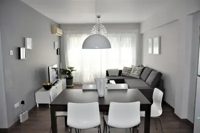 a dining room and living room with a table and chairs at Liliana Sea View Suite in Larnaka