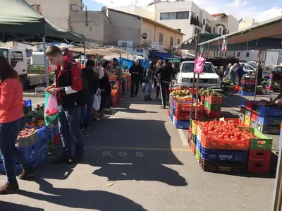 a group of people walking around a market with produce at Liliana Sea View Suite in Larnaka