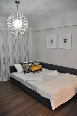 a bedroom with a large bed with a chandelier at Liliana Sea View Suite in Larnaka