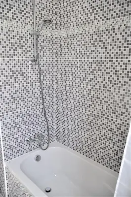 a shower in a tiled bathroom with a sink at Liliana Sea View Suite in Larnaka