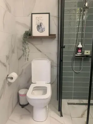 a bathroom with a white toilet and a shower at Antonia Sea View Suite in Larnaka