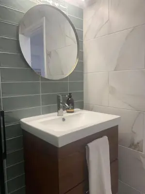 a bathroom with a white sink and a mirror at Antonia Sea View Suite in Larnaka