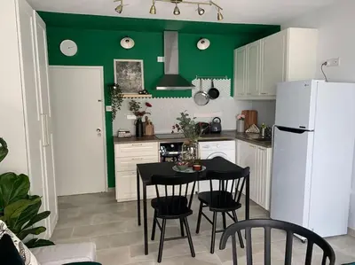 a kitchen with a table and chairs and a white refrigerator at Aria Sea View Studio in Larnaka