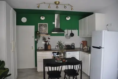 a kitchen with a table and a white refrigerator at Aria Sea View Studio in Larnaka