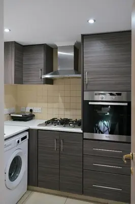 a kitchen with a stove and a washing machine at Oikou Thea Guesthouse in Oikos