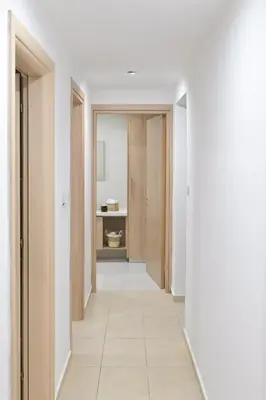 an empty hallway with white walls and a white floor at Oikou Thea Guesthouse in Oikos