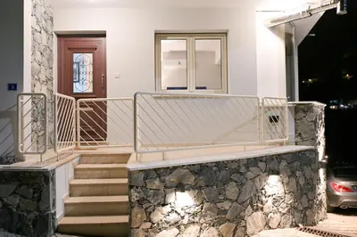 a white house with a staircase and a door at Oikou Thea Guesthouse in Oikos