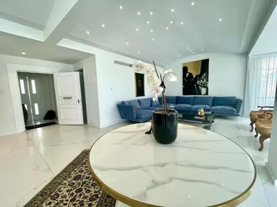 a living room with a table and a blue couch at Penthouse Luxury Apartment in Nicosia
