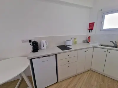 a small kitchen with white cabinets and a sink at Kitieos Central Apts 100m from Finikoudes Beach in Larnaka