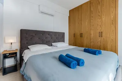 a bedroom with a large bed with blue pillows on it at Seaview Sanctuary House in Larnaka