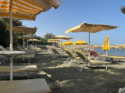 a bunch of chairs and umbrellas on a beach at Seaview Sanctuary House in Larnaka