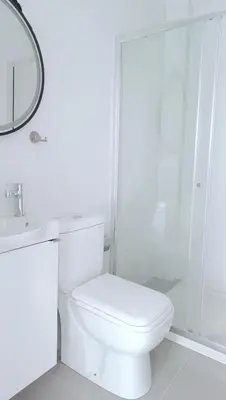 a white bathroom with a toilet and a mirror at Larvella Estia Luxury Suites in Larnaka